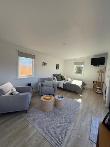 a living room with two couches and a tv at Mont-Eggo Boutique Garden Studio in New Town