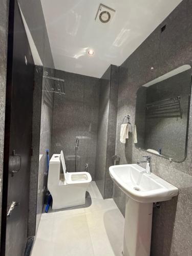 a bathroom with a sink and a toilet and a mirror at HOTEL ATULYAM STAYs PREMIUM in Prayagraj