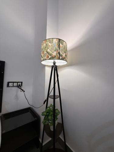 a lamp in a room with a plant next to it at HOTEL ATULYAM STAYs PREMIUM in Prayagraj