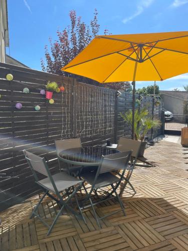 a table and chairs with an umbrella on a patio at A l'Abri du Temps in Châteaudun