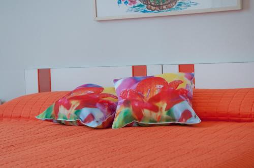 two colorful pillows sitting on top of a bed at Albergo La Rosetta in Chianciano Terme