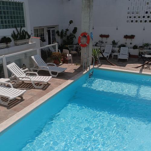 a large blue swimming pool with chairs and a table at Estalagem da Liberdade in Portalegre