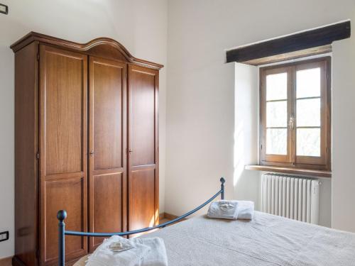 a bedroom with a bed and a wooden cabinet at Authentic Marche Hideaway in SantʼAngelo in Vado