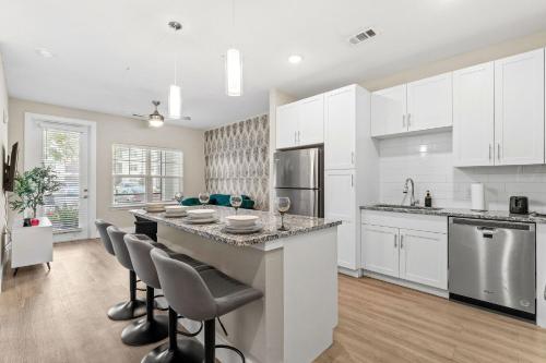 a kitchen with white cabinets and a large island at Pinnacle Apartments W Amenties by Heavenly Homes in Orlando