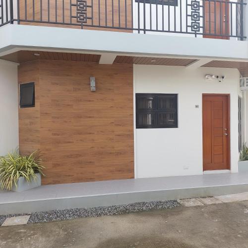 a wooden garage door on a house with a balcony at Apartment at the heart of Batangas City in Batangas City