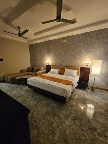Un dormitorio con una cama grande y un sofá. en Hotel Cedara, en Haldwāni