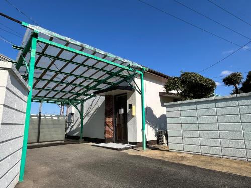 a green pergola over the entrance to a house at Win Village in Sasebo