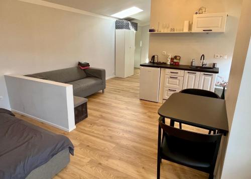 een kleine kamer met een bank, een tafel en een keuken bij Old Town Quiet Rooftop Studio Apartment in Rīga