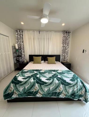 a bedroom with a large bed with a colorful blanket at MIAMI ROOMs in Miami