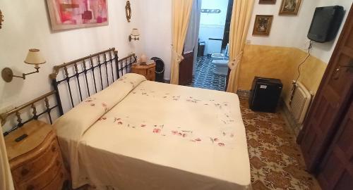 a bedroom with a bed with flowers on it at Benafique La casa del Ciprés Cortegana in Cortegana