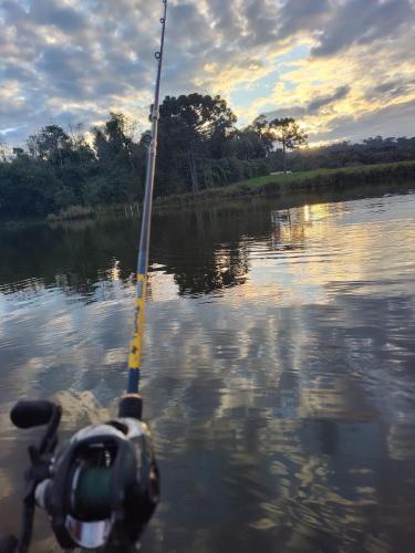 a boat with a fishing pole in the water at Cabana de pesca e lazer Represa Usina Mafra sc in Mafra