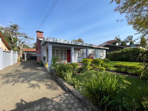 ein weißes Haus mit Auffahrt in der Unterkunft Garden Villa 5BR Home Near Road,Nature and City Life in Arusha