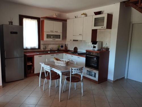 Una cocina con mesa y sillas y un refrigerador. en Casa vacanze Sara, en Gagno