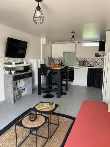 a living room with a table and a kitchen at A l'Abri du Temps in Châteaudun