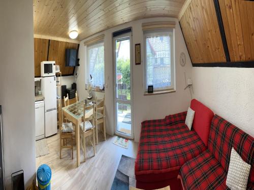 a living room with a red couch and a kitchen at Holiday Home near Klínovec Ski Lift in Loučná pod Klínovcem