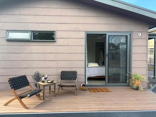 a patio with two chairs and a table and a bedroom at Guest suite in Phillip Island in Cape Woolamai