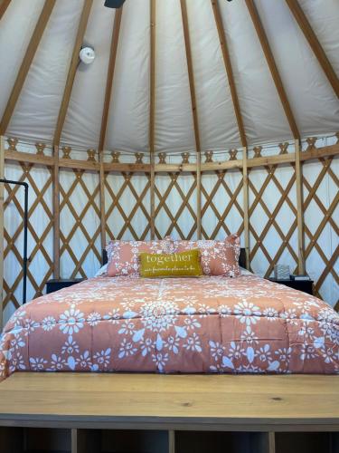 a bed in a yurt with a pillow on a bench at Mountain Aire Cottages, Inn, & Glamping in Clayton