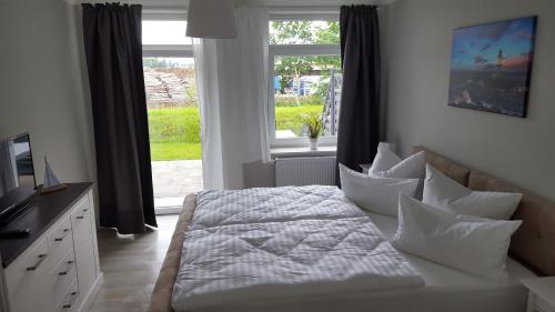 a bedroom with a bed with pillows and a window at Pension Fischerjung in Rostock