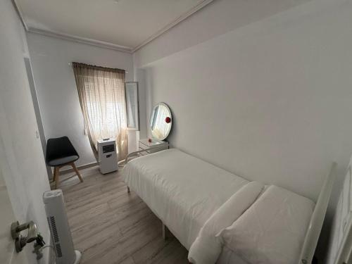 a white bedroom with a bed and a mirror at SuecaRoom in Sueca