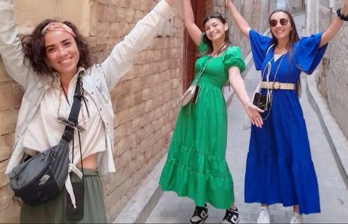 a group of three women standing next to a brick wall at hébergement - Errachidia, Maroc in Er Rachidia