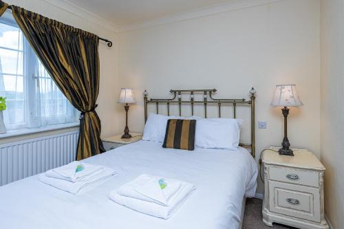 a bedroom with a bed with two towels on it at Northop Hall Country House Hotel in Mold