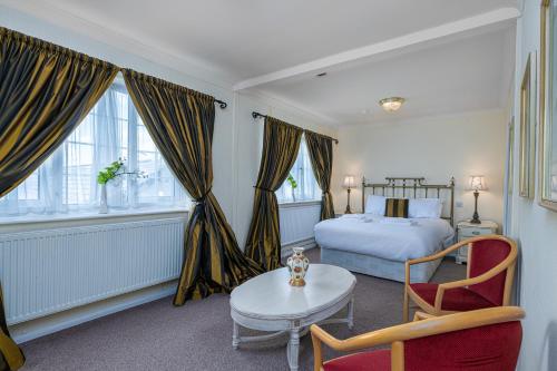 a bedroom with a bed and a table and a chair at Northop Hall Country House Hotel in Mold
