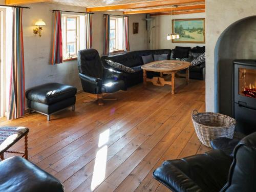 a living room with black leather furniture and a table at 4 star holiday home in Hadsund in Hadsund