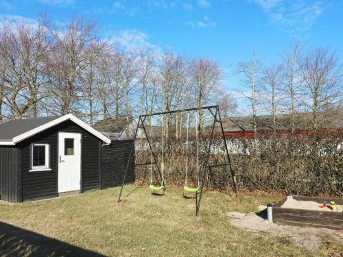 a swing set in a yard with a shed at 10 person holiday home in Hadsund in Hadsund