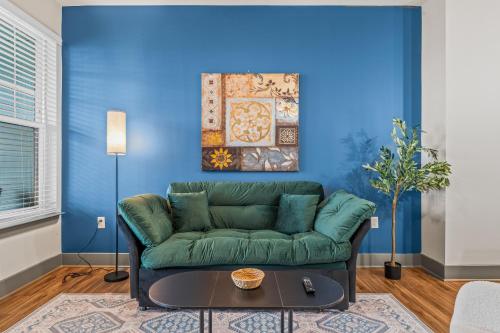 a living room with a green couch and a blue wall at Monarch Apartments 15m to Parks, Pet Friendly, Free Parking by Heavenly Homes in Orlando