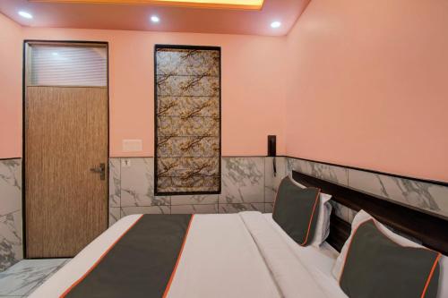 a bedroom with a bed and a door at Hotel O Rasuj in Jaipur