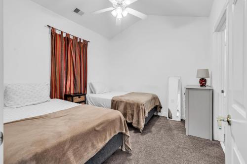 a bedroom with two beds and a ceiling fan at Myrtlewood by Monarch Rentals in Myrtle Beach
