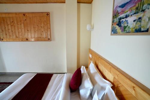 a bedroom with a bed and a painting on the wall at Echoes of Nirvana in Theog