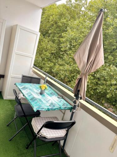 a balcony with a table and chairs and an umbrella at Cozy appartement in oberbarmen in Wuppertal