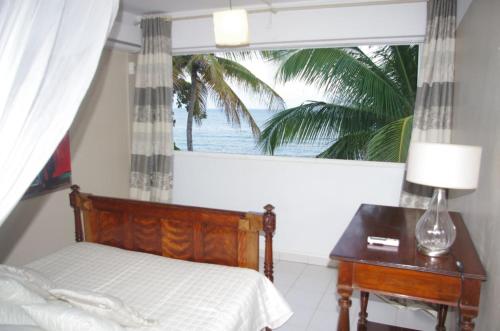 Ένα ή περισσότερα κρεβάτια σε δωμάτιο στο Villa VICTORIA, le paradis les pieds dans l'eau