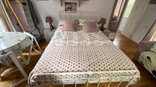 a bedroom with a white bed with pink pillows at Exmoor BnB in Withypool on Two Moors Way in Withypool