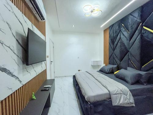 a bedroom with a large bed and a tv at CASONEViIIE apartments lekki in Lagos