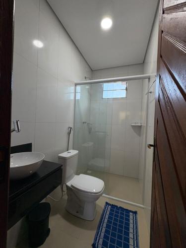 a bathroom with a toilet and a sink and a shower at Recanto Mandacaru in Queimada