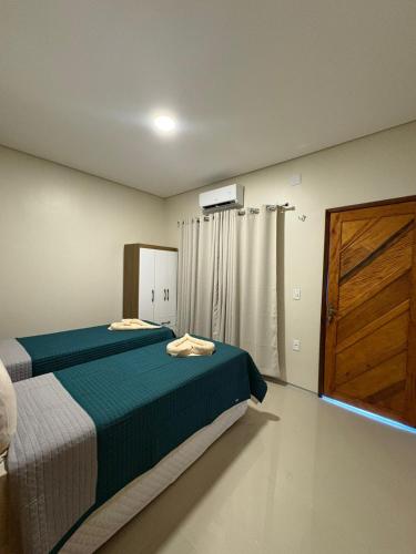 a bedroom with a bed and a wooden door at Recanto Mandacaru in Queimada