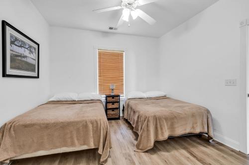 a bedroom with two beds and a ceiling fan at Myrtlewood by Monarch Rentals in Myrtle Beach