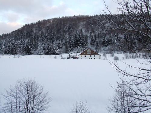 a house in the middle of a snow covered field at Domaine Des Hauts Viaux in La Bresse