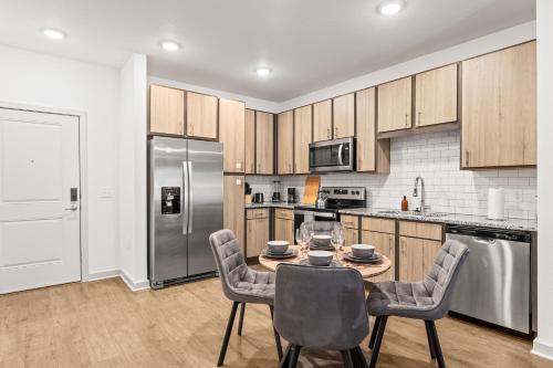 Adeline Apartments 15m to Parks, Pet Friendly, Free Parking by Heavenly Homes في أورلاندو: مطبخ مع طاولة وكراسي وثلاجة