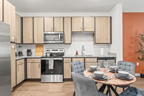 Adeline Apartments 15m to Parks, Pet Friendly, Free Parking by Heavenly Homes في أورلاندو: مطبخ مفتوح مع طاولة وكراسي في الغرفة