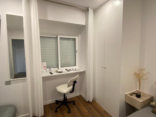 Dieses weiße Zimmer verfügt über einen Schreibtisch und einen Stuhl. in der Unterkunft Casa da Covilhã - Pedra e Lã in Covilhã