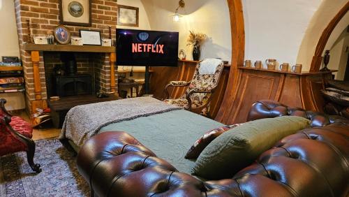 a living room with a leather couch and a fireplace at West Stow Pods in Bury St Edmunds in West Stow