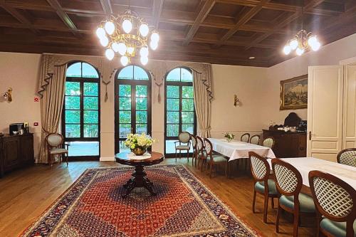 a dining room with a table and chairs and a chandelier at Tilia Kúria in Bózsva