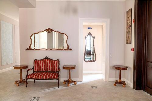 a living room with a chair and a mirror at Tilia Kúria in Bózsva