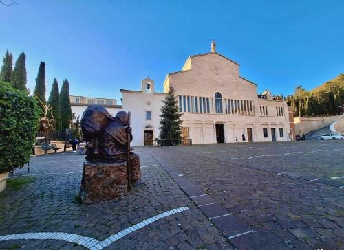 a statue of a person on a street in front of a building at Hotel San Francesco in San Giovanni Rotondo