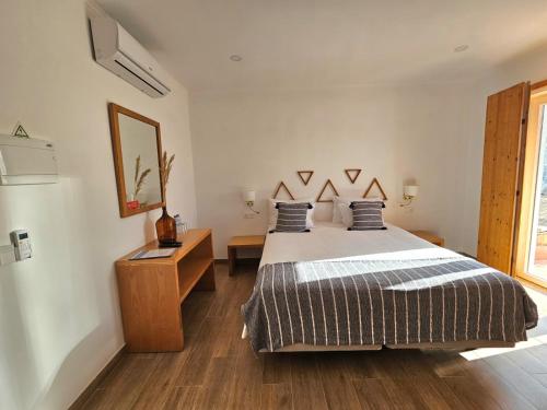 a bedroom with a bed and a dresser and a mirror at Herdadinha in Vimieiro