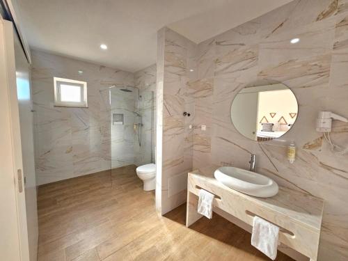 a bathroom with a sink and a toilet and a mirror at Herdadinha in Vimieiro