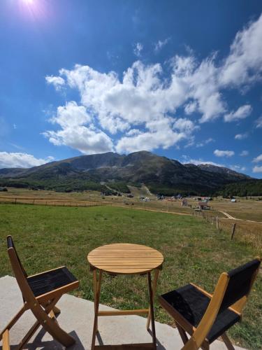 a table and two chairs sitting next to a field at Mountain Peace in Žabljak